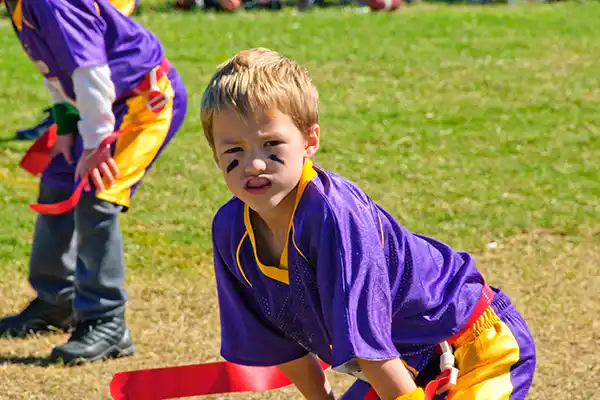 A young flag football player wearing a sports guard as he practices his sport.